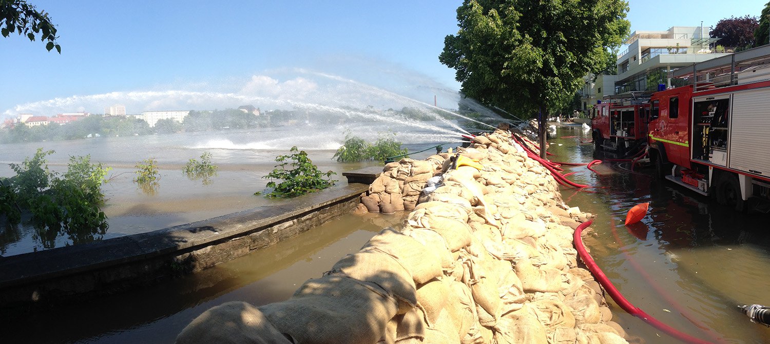 Feuerwehrfahrzeuge pumpen Wasser zurück beim Hochwasser in Magdeburg 2013